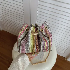 Handmade woven drawstring bucket bag with colorful stripes and gold chain strap
