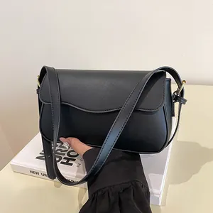 Minimalist black matte leather shoulder bag with wave-edge flap and gold hardware