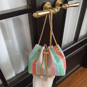Colorful zigzag knit bucket bag with gold chain strap and pearl drawstring accents
