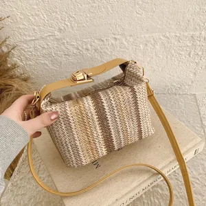 Striped woven straw crossbody bag with yellow leather strap and gold metallic buckle lock