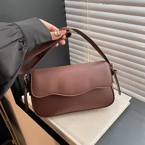Chic brown wave-flap crossbody bag in matte faux leather with gold-tone hardware