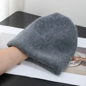Dettaglio del berretto in maglia grigio scuro in pelo di coniglio con consistenza morbida e calda