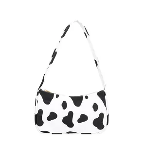 Fashionable cow print underarm bag with black and white spots and gold zipper