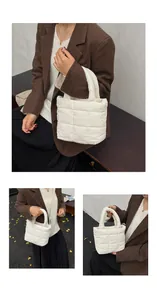 Close-up of cream quilted puffy bag with glossy nylon texture and large grid stitching