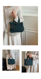 Nahaufnahme der dunkelgrünen Stricktasche mit strukturierter Webart und Herz-Anhänger