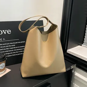 Minimalist beige leather tote bag with gold FASHION embossing in a lifestyle setting