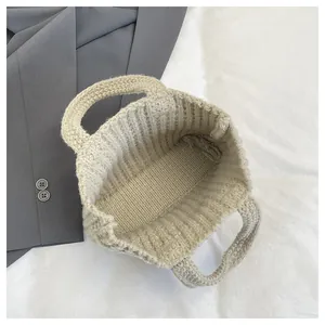 Detailansicht der beigen Stricktasche mit Fokus auf Grobstrickmuster und Innenstruktur
