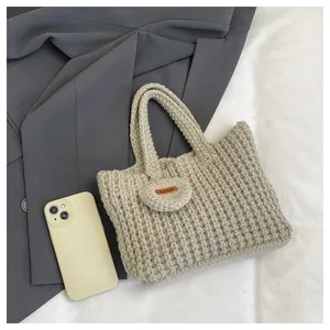 Detail der handgefertigten beigen Stricktasche mit Herzanhänger und Hand Made Lederetikett