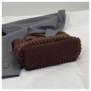 Detailansicht der dicken dunkelbraunen Strickstruktur und des Webmusters der Tasche