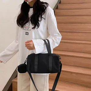 Minimalist black canvas boston bag with adjustable strap and small round coin purse
