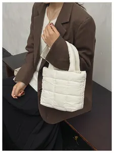 Detailed close-up of a quilted white padded tote bag with a soft puffer texture and handles