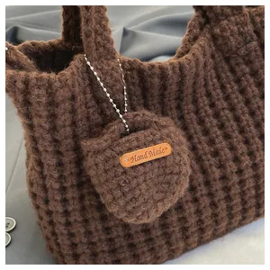 Detailaufnahme der handgehäkelten kaffeebraunen Handtasche mit kleiner runder Geldbörse