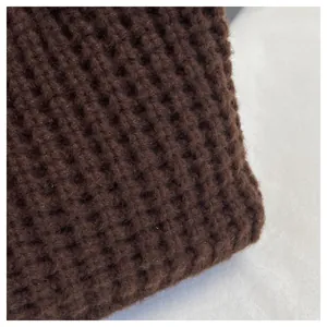 Detailaufnahme der dicken, schokobraunen Waffelstrick-Textur und des weichen handgewebten Stoffes