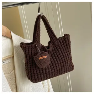 Nahaufnahme braune Stricktasche mit Waffelmuster und 'Hand Made' Herz-Anhänger