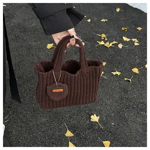 Detail der kaffeebraunen Stricktasche mit handgefertigtem Holztag und Herzanhänger