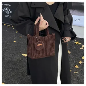 Detail einer handgefertigten dunkelbraunen Stricktasche mit Hand Made Leder-Etikett