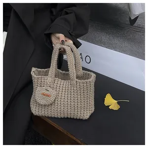 Detail einer handgefertigten Stricktasche mit klarer Textur und Lederetikett