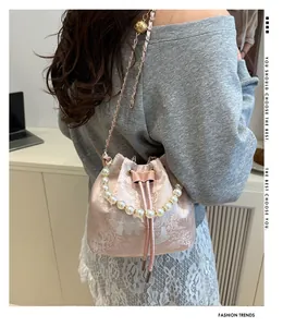 Close-up of pink jacquard bucket bag featuring pearl handle and gold chain strap