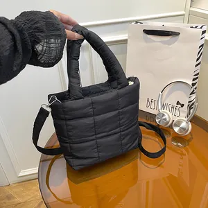 Chic black quilted puffer tote bag with adjustable shoulder strap and puffy texture