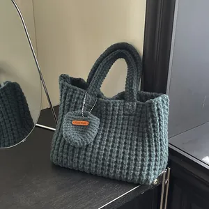 Dunkelgrau-grüne handgestrickte Tragetasche aus dicker Wolle mit handgemachtem Lederetikett