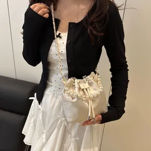 Elegant white floral drawstring bucket bag with pearl handle and metal chain strap