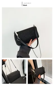 Detail of black rhinestone evening bag with silver chain strap and beaded pendant