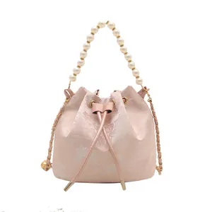 Pink jacquard bucket bag with pearl handle and Chinese landscape pattern on white background