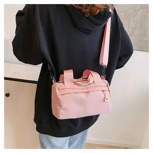 Bolso Boston de nailon rosa con bandolera ajustable y bolsillo exterior con cremallera