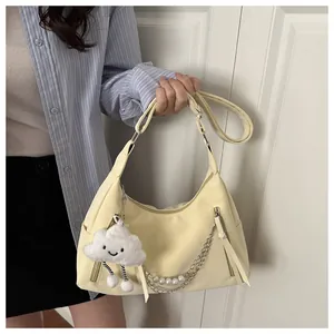 Detail of cream yellow half-moon bag with pearl chain and cute cloud plush charm