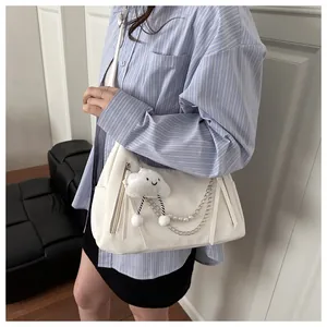 Detail of white leather shoulder bag with silver chains, pearls and cloud pendant