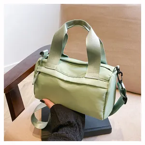 Primer plano de bolso de nailon verde menta con asas dobles y correa de tela ajustable
