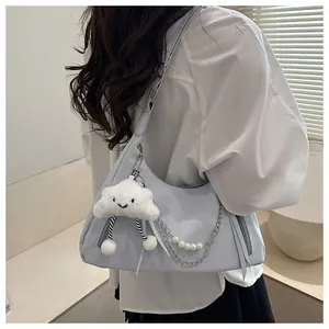 Detail of light blue hobo bag with pearl chain and white cloud plush charm