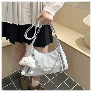 Close-up of light blue hobo bag with pearl chain detail and cloud plush charm