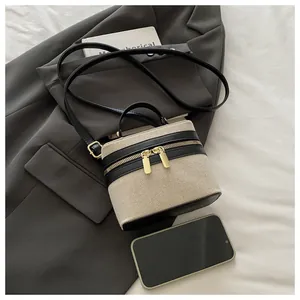 Close-up of contrast patchwork box bag with woven texture and gold zipper details