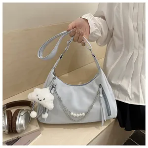 Detail of light blue crescent bag with silver chain, pearls and plush cloud charm