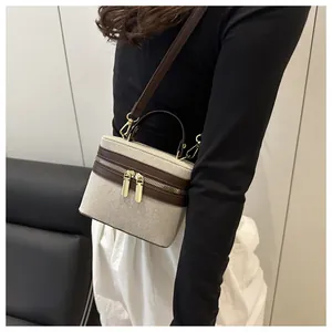 Detail of color-block box bag featuring canvas leather texture and gold hardware