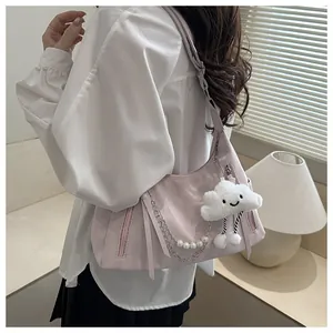 Detail of pink hobo bag with pearl chain, plush cloud charm on a model's shoulder