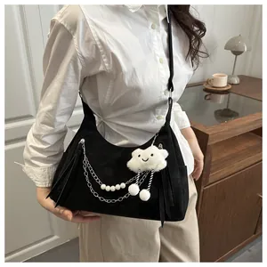 Detail of black crescent bag with pearl metal chain and plush cloud charm accessory