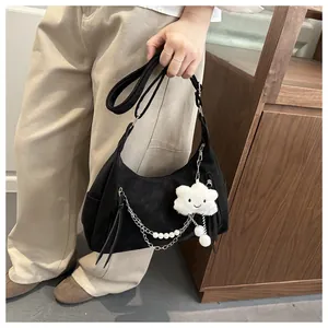 Detail of black nylon shoulder bag with pearl charm, metal chain and plush cloud pendant
