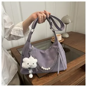 Close-up of lavender shoulder bag featuring metal chains, pearls, and cloud charm