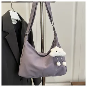 Detail of purple crescent shoulder bag featuring a cute white cloud plush pendant charm