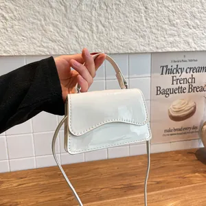 Mini sac carré en cuir verni blanc brillant avec rabat ondulé et bandoulière