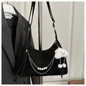 Detail of black crescent shoulder bag with pearl chain and white cloud plush charm