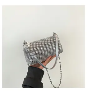 Detail of silver rhinestone clutch featuring pearls and a sleek metal chain strap