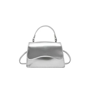 Sac bandoulière argenté minimaliste avec rabat ondulé et poignée supérieure ronde