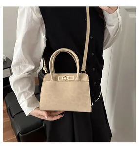Détail de l'imprimé léopard sur cuir beige et du fermoir tournant doré du sac à main