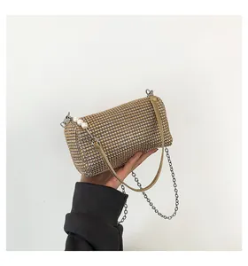 Detail of gold rhinestone clutch bag with pearl handle and silver metal chain strap