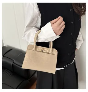 Détail du sac à main beige embossé léopard avec fermoir doré et poignées rondes