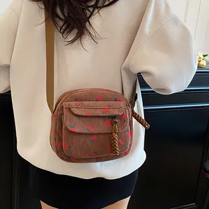 Brown corduroy mini crossbody bag with red strawberry print and front flap pocket