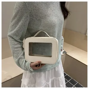 Detail of the cream-colored portable makeup bag with clear PVC window and sturdy handle